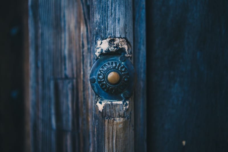Battery video doorbell mounted beside a front door